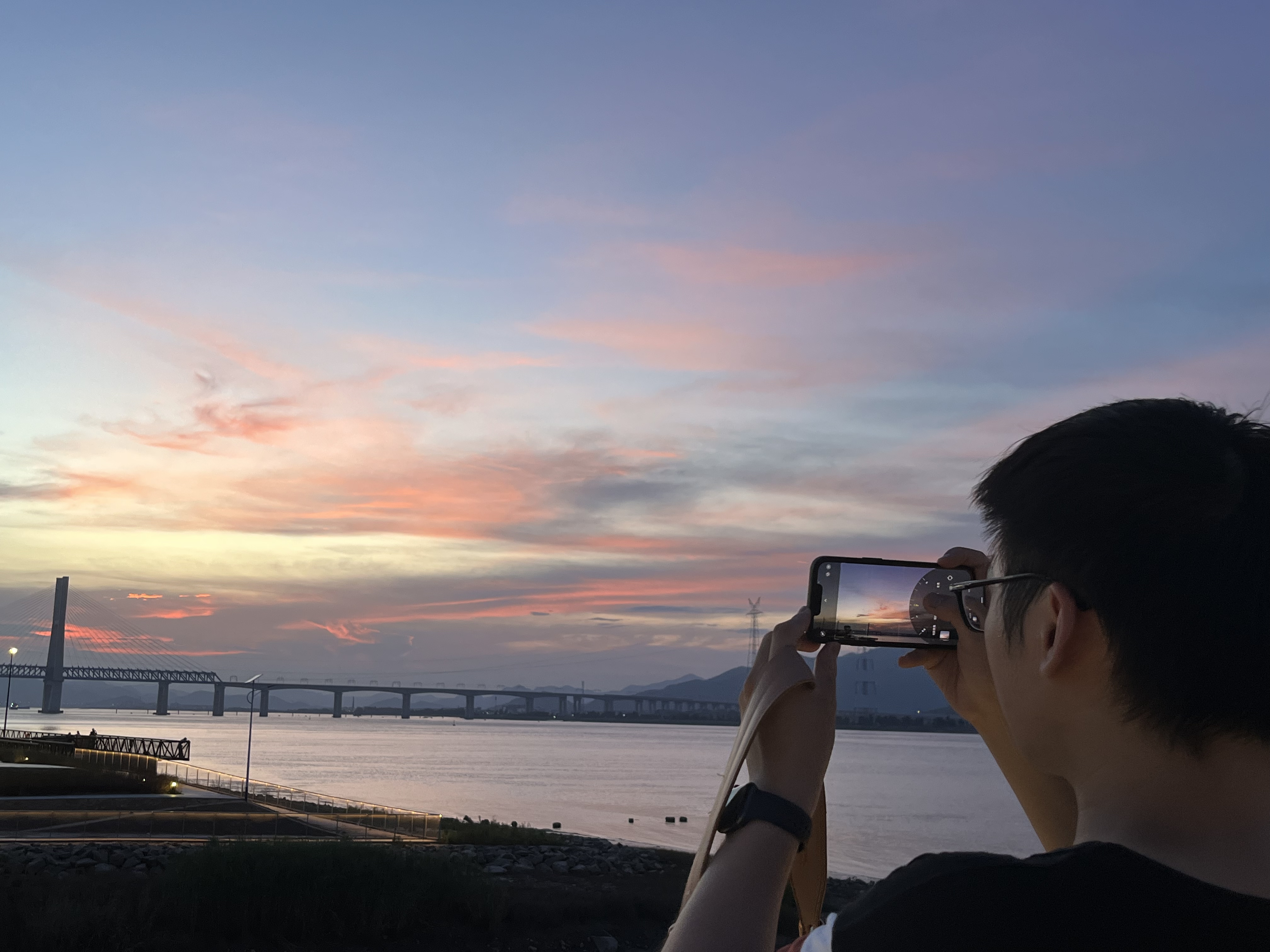 Xing Su beside a river at sunset